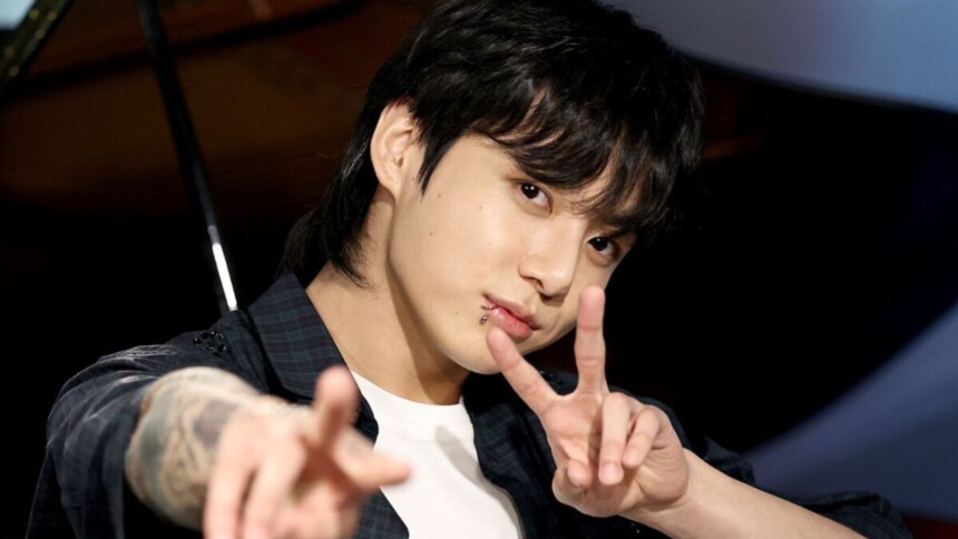 Jungkook, astro do BTS, posando fazendo sinal com os dedos
