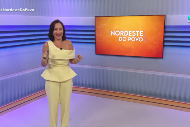 Katiuzia Rios em pé no centro do cenário do Nordeste do Povo na RedeTV!. Ela está sorridente