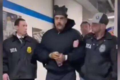 Nicolás Maduro caminha de casaco preto e algemado por um corredor da Agência Antidrogas nos EUA