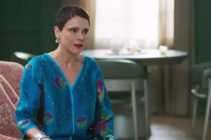 Malu Galli como Tia Celina sentada no sofá em cena da novela Vale Tudo