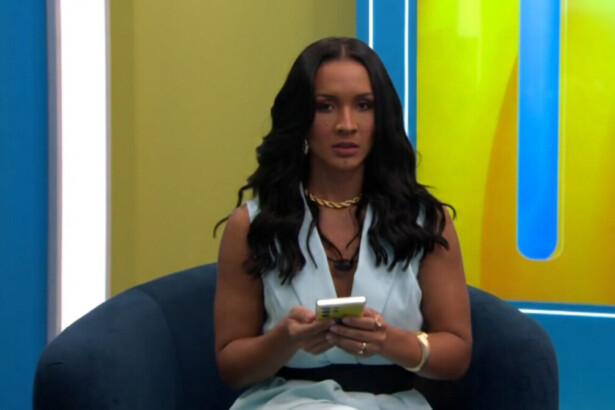 Maxiane com um celular na mão em trecho de dinâmica no BBB 26