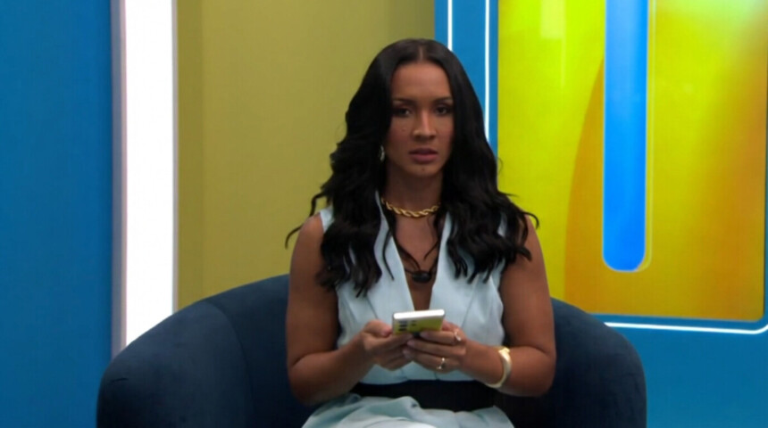 Maxiane com um celular na mão em trecho de dinâmica no BBB 26