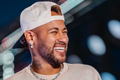 Neymar de boné para trás e sorridente