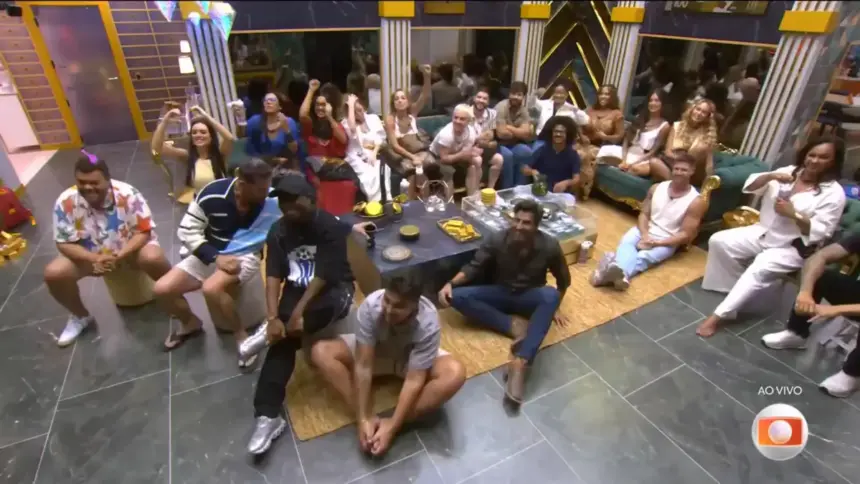 Todos os participantes do BBB 26 sentados no chão da sala do casa