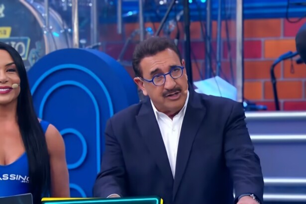 Ratinho apresentando o programa no SBT ao lado de uma bailarina com uma blusa escrito Cassino