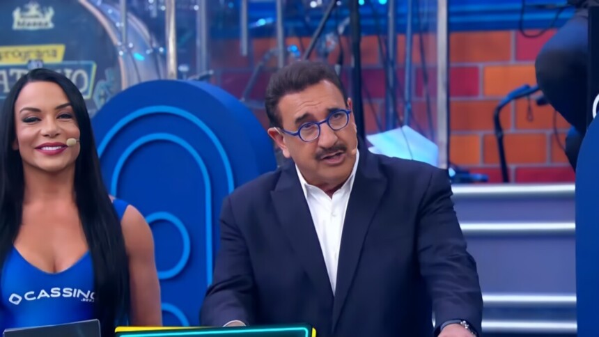Ratinho apresentando o programa no SBT ao lado de uma bailarina com uma blusa escrito Cassino