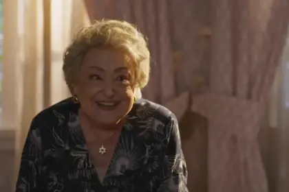 Suely Franco sorrindo em um quarto da cenografia de Dona de Mim