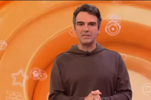 Tadeu Schmidt de casaco marrom no estúdio do BBB 26 anuncia a dinâmica da semana