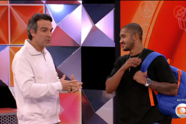 Tadeu Schmidt ao lado de Matheus no estúdio do BBB 26. Os dois estão em pé, o participante segura sua mochila após a leiminação