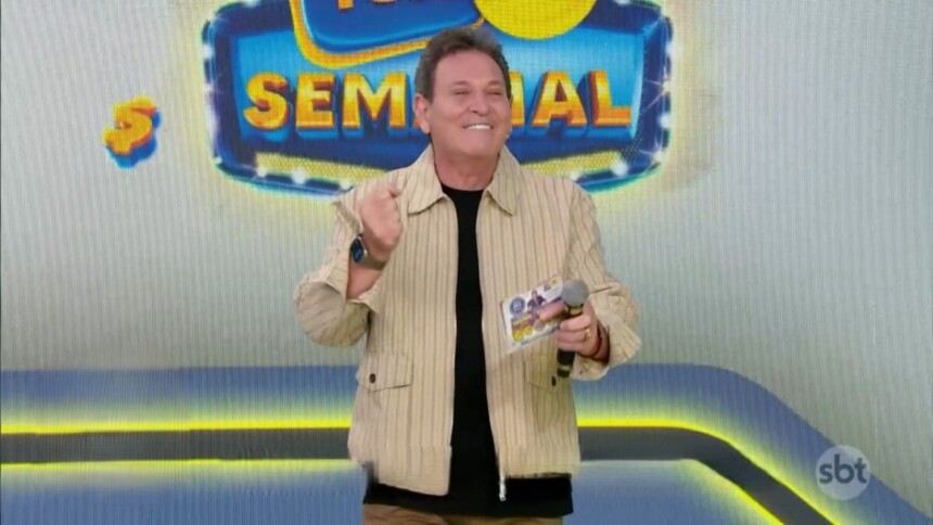 Luis Ricardo sorrir e segura o bilhete da edição 85 da Tele Sena Semanal