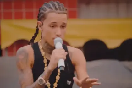 Theuzinho segura microfone e canta em uma rua. Cantor é destaque do programa Encontro