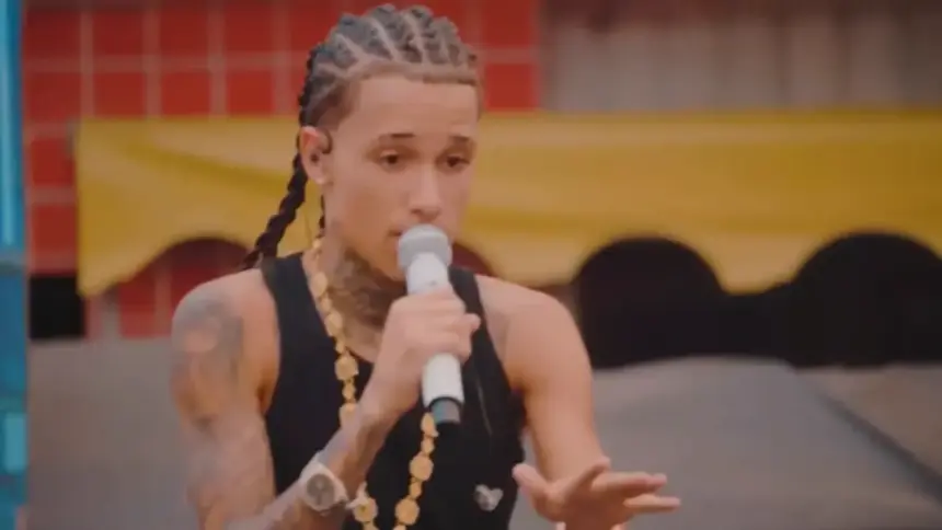 Theuzinho segura microfone e canta em uma rua. Cantor é destaque do programa Encontro