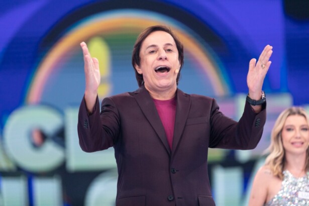 Tom Cavalcante com os braços abertos e levantados para cima todo sorridente no palco do Acerte ou Caia!