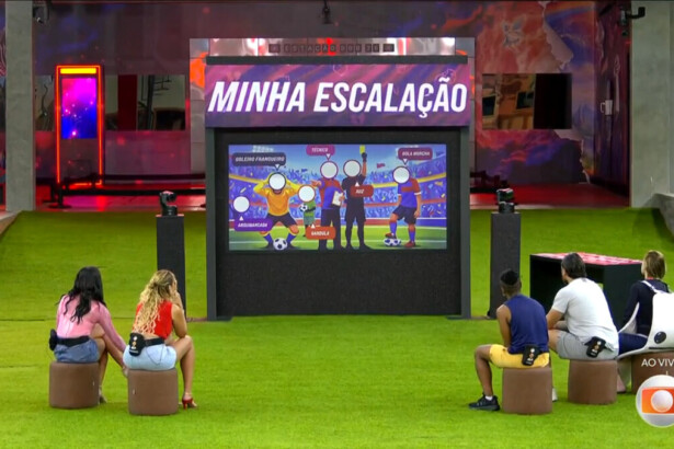 Brothers sentados no gramado olham para o painel da escalação do Sincerão no BBB 26