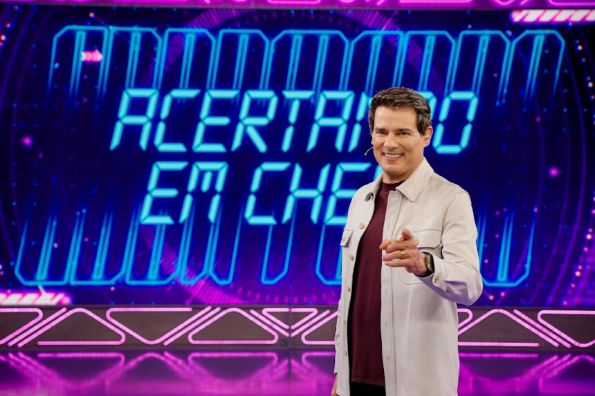 Celso Portiolli em frente ao telão com o logo do novo game Acertando em Cheio do Domingo Legal