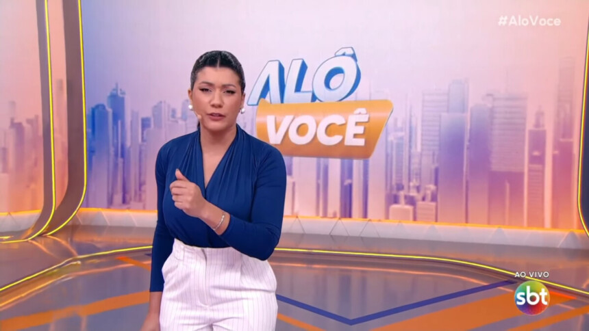 Dani Brandi em pé no cenário do Alô Você