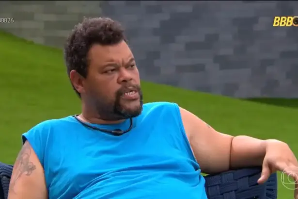 Babu veste camisa azul, sentado na área externa do BBB 26, contando para os aliados sobre o puxão de orelha da produção