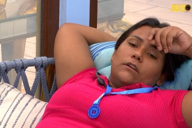 Chaiany deitada na área externa do BBB 26 com o colar do anjo