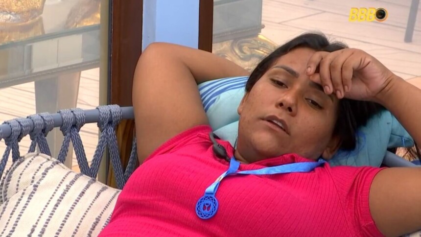 Chaiany deitada na área externa do BBB 26 com o colar do anjo