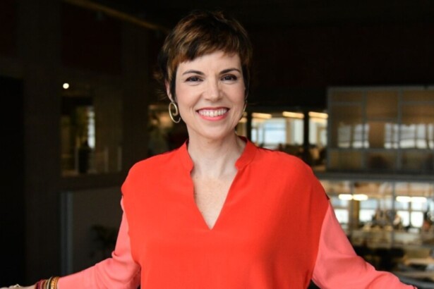 Gloria Vanique sorrindo e posando na sede da TV Gazeta