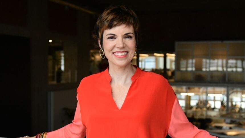 Gloria Vanique sorrindo e posando na sede da TV Gazeta