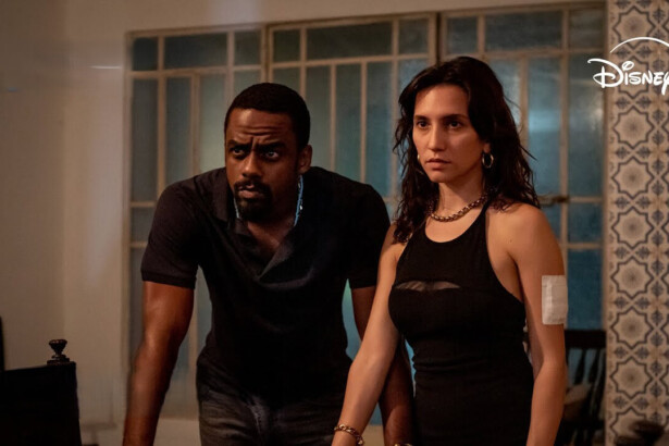 Casal de protagonistas da série Impuros com olhares atentos dentro de uma casa simples no Rio de Janeiro