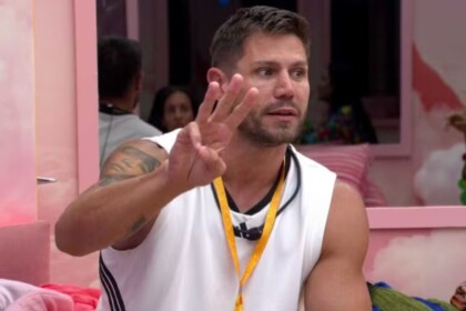 Jonas fazendo o sinal de três com as mãos em conversa no quarto rosa do BBB 26