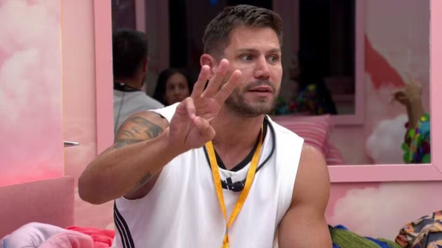 Jonas fazendo o sinal de três com as mãos em conversa no quarto rosa do BBB 26