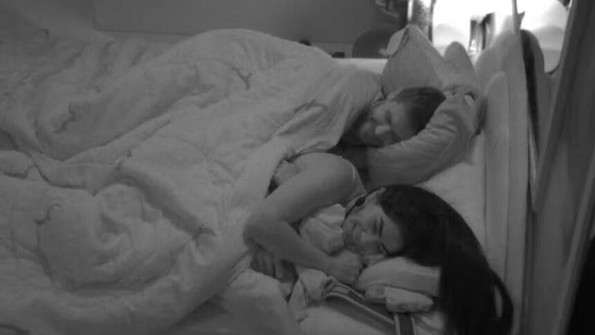 Jonas e Marciele deitados na cama do quarto escuro do BBB 26