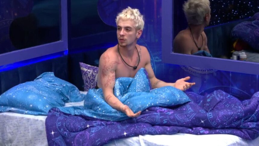 Juliano Floss deitado na cama, com feição surpresa, no BBB 26