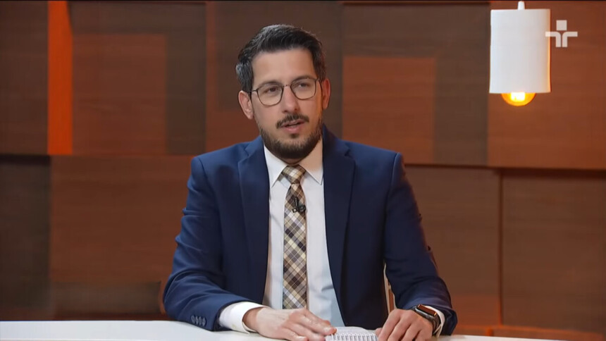 Luis Corvini de terno e gravata sentado na bancada do programa Legião Estrangeira da TV Cultura, antes de assinar com a TV Gazeta