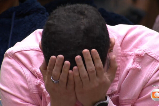 Marcelo chora com as mãos no rosto sentado na sala do BBB 26