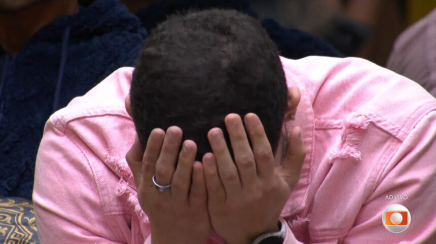 Marcelo chora com as mãos no rosto sentado na sala do BBB 26