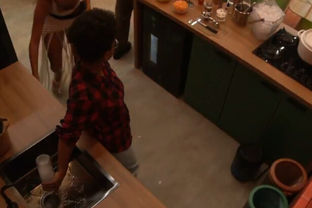 Milena virando uma garrafa de bebida na pia da festa no BBB 26