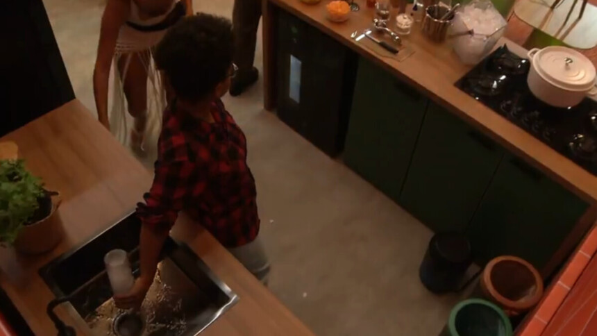 Milena virando uma garrafa de bebida na pia da festa no BBB 26