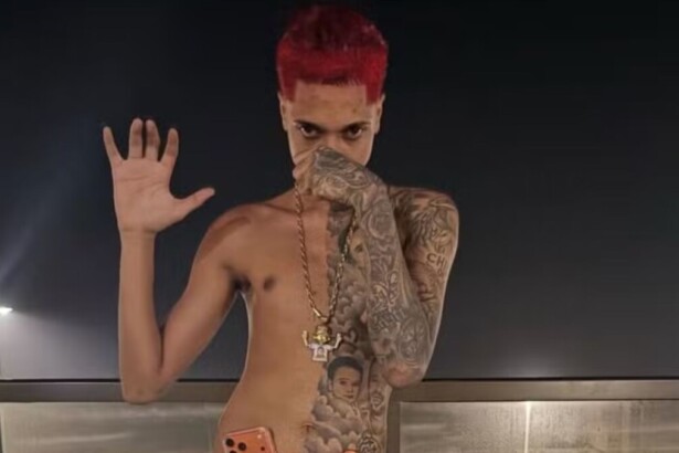 Rapper Oruam sem camisa, de cabelo vermelho e mostrando tatuagem pelo corpo