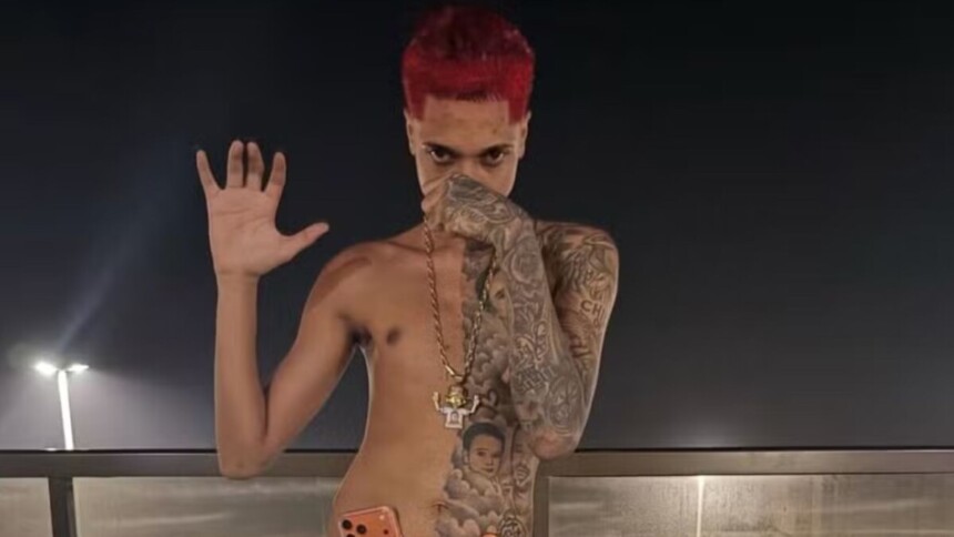 Rapper Oruam sem camisa, de cabelo vermelho e mostrando tatuagem pelo corpo