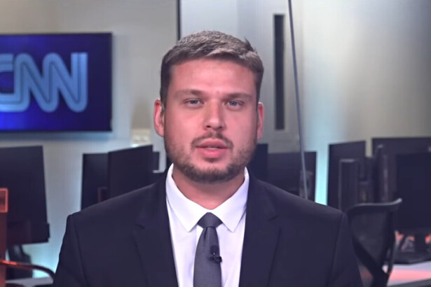 Pedro Teixeira de terno e gravata na redação da CNN Brasil