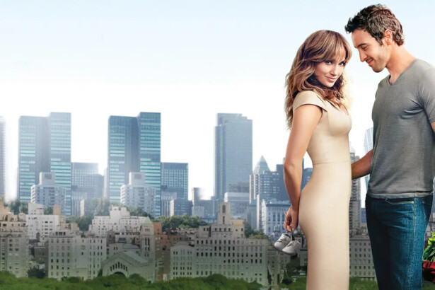 Jennifer Lopez e Alex O'Loughlin se olhando e ao fundo uma cidade com muitos prédios em cena do filme Plano B