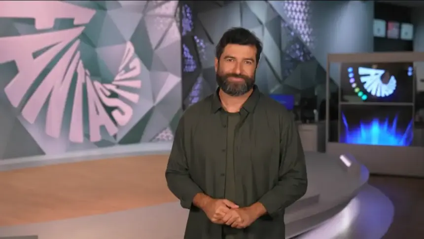 Rodrigo Carvalho sorridente no palco do Fantástico gravando a chamada do programa