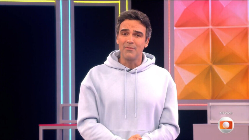 Tadeu Schmidt de moletom branco apresentando a dinâmica da semana do BBB 26