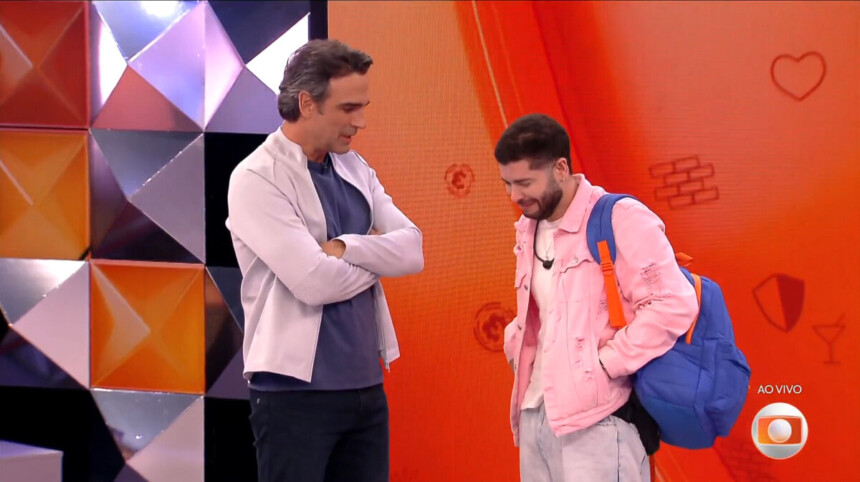 Tadeu Schmidt em pé na frente de Marcelo no estúdio do BBB 26