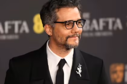 Wagner Moura olha para os footógrafos no tapete vermelho do Bafta