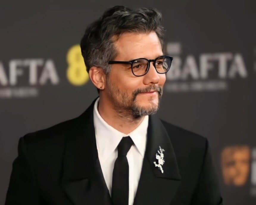 Wagner Moura olha para os footógrafos no tapete vermelho do Bafta