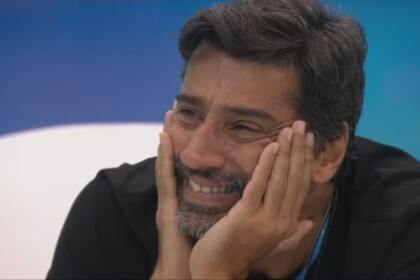 Alberto Cowboy, sorridente, com a mão no rosto, em trecho do Presente do Anjo no BBB 26
