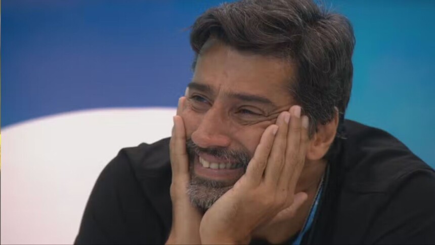 Alberto Cowboy, sorridente, com a mão no rosto, em trecho do Presente do Anjo no BBB 26