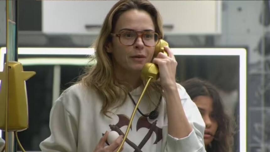 Ana Paula Renault atendendo o Big Fone amarelo na cozinha do BBB 26