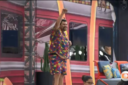 Babu Santana na porta de entrada da área externa do BBB 26 acenando para os brothers após eliminação do BBB 26