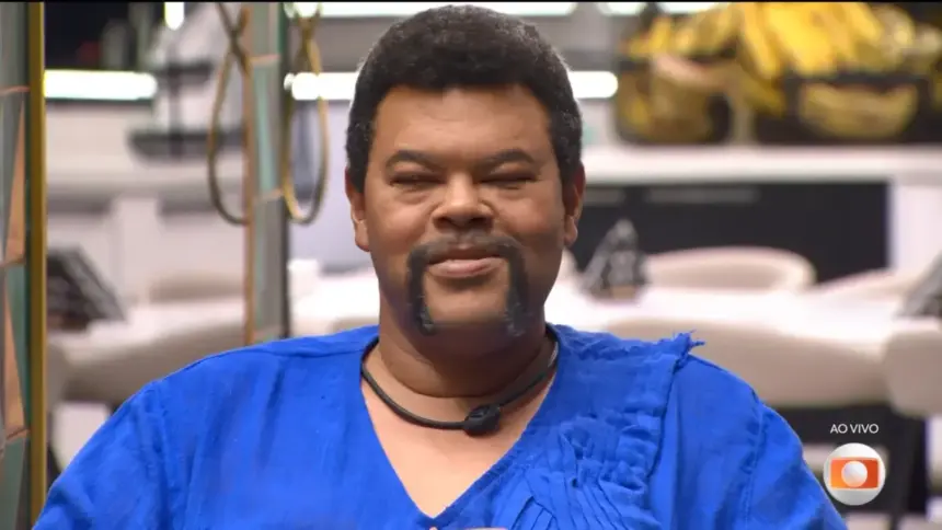 Babu vestido de azul e com semblante sério ao ser emparedado na sala do BBB 26