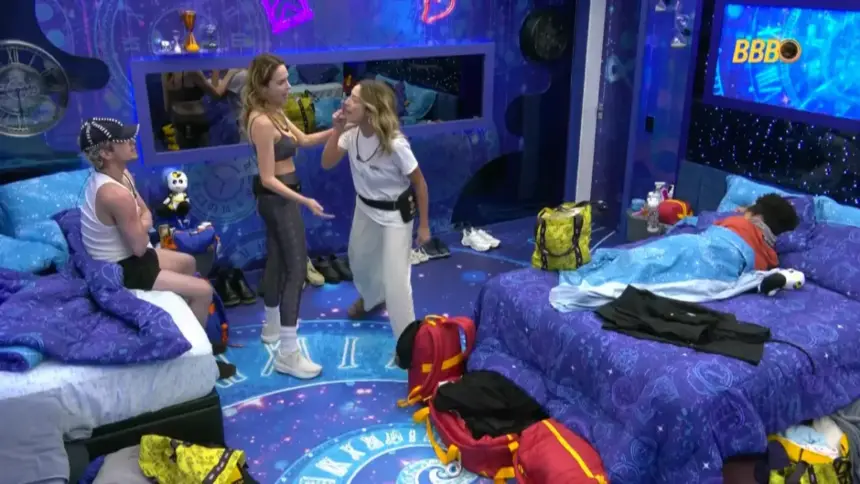 Ana Paula Renault tenta separar briga de Samira que está em pé apontando o dedo para Juliano. Ele está sentado na cama do quarto do BBB 26